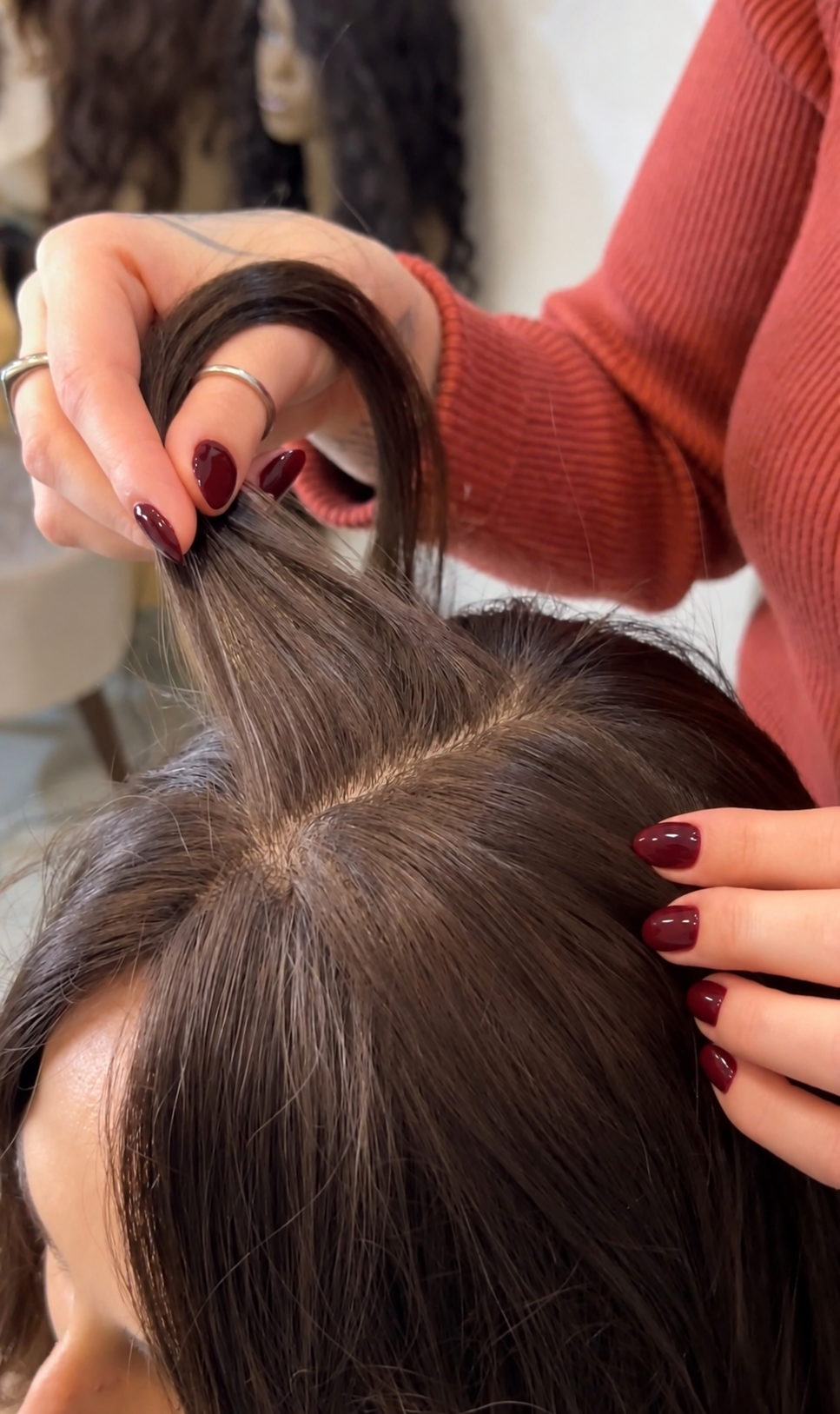 Profissional ajustando prótese capilar em cabelo escuro na Magma, em Florianópolis